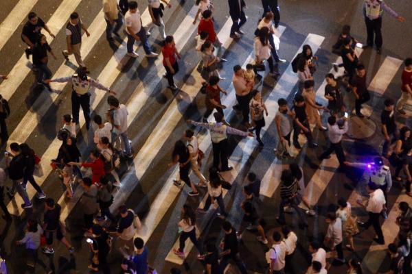 公安民警将过马路的来往人群隔离.