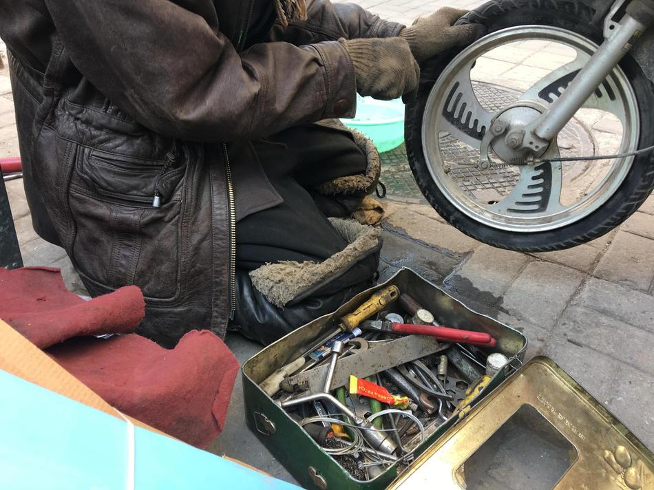 82岁老人跪地修车30年为两病儿送终