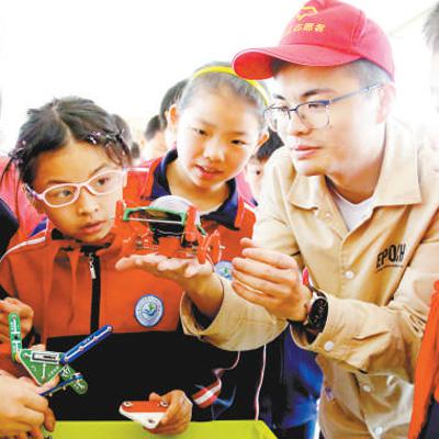 江西省峡江县第二实验小学学生在科普志愿者的指导下体验科技展品。 曾双全摄