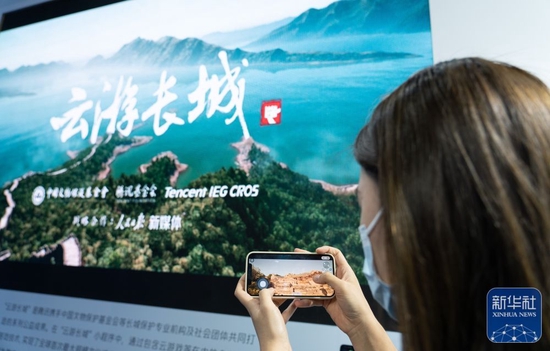 在位于北京国家会议中心的2022全球数字经济大会元宇宙体验馆，一名工作人员展示“云游长城”小程序（2022年7月28日摄）。新华社记者 陈钟昊 摄