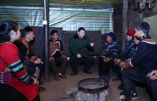 ↑2018年2月11日,习近平在四川凉山彝族自治州昭觉县三岔河乡三河村节列俄阿木家中同村民代表、驻村扶贫工作队员围坐火塘边,共谋精准脱贫之策。