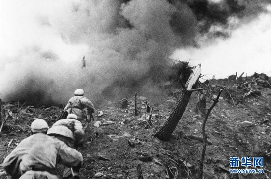 1952年，在上甘岭战役中，中国人民志愿军指战员在炮火支援下，攻上537.7高地北山。新华社发