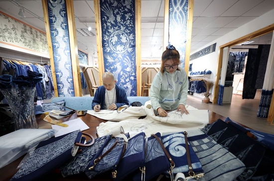 2022年4月7日，在贵州省黔东南苗族侗族自治州丹寨县宁航蜡染非遗工坊，服饰设计师在设计蜡染产品。 新华社发（黄晓海 摄）