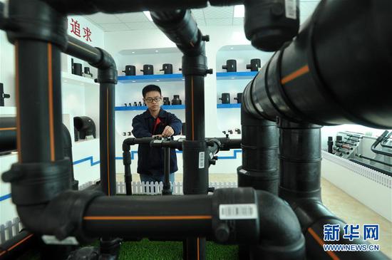 工人在河北省沧州市孟村回族自治县一家管道制造企业样品展室内工作（5月6日摄）。  新华社记者 牟宇 摄