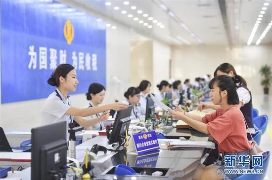 国家税务总局泉州市税务局丰泽街办税服务厅的工作人员在新办企业服务窗口为纳税人办理业务(2018年9月13日摄)。国地税合并后,国家税务总局福建省税务局在全省推行新办纳税人“套餐式”服务。 新华社记者 宋为伟 摄
