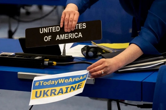 ▲ 美国等西方国家用尽一切机会，在各种场合造势施压。图为2022年3月2日，美国驻国际原子能机构代表团成员在桌签前张贴“今天我们都是乌克兰”的标语