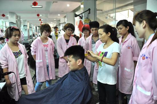 2014年6月23日，山东蓝翔高级技工学校美容美发专业的学生在观看老师的教学示范。