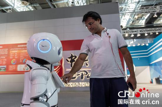 亚希尔在中关村国家自主创新示范展示中心与智能机器人进行互动 摄影 沈湜