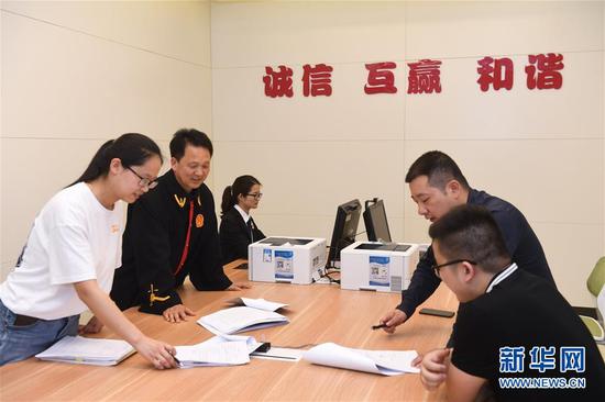 4月25日,浙江省诸暨市人民法院值班法官吴尚伟(左二)在调解一起侵害作品信息网络传播权纠纷。 新华社记者 翁忻旸 摄