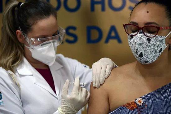 （图说：8月8日，护士瓜索在巴西阿雷格里港的一家医院为另一名护士苏扎注射科兴试验疫苗/图源：路透社）