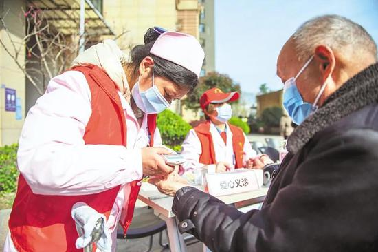 3月4日，武漢市青山區(qū)紅鋼城街道二街社區(qū)，志愿者在為居民測血脂。（湖北日報全媒記者 何宇欣 通訊員 陳立峰 攝）
