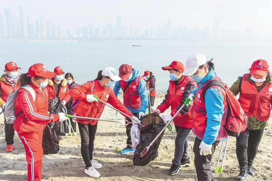 2月2日下午，武漢市江灘辦在漢口江灘沿江灘地開展的“我愛母親河 清潔灘地我們在行動”活動中，志愿者在撿拾垃圾，清潔灘地。（湖北日報全媒記者 梅濤 通訊員 向麗華 攝）