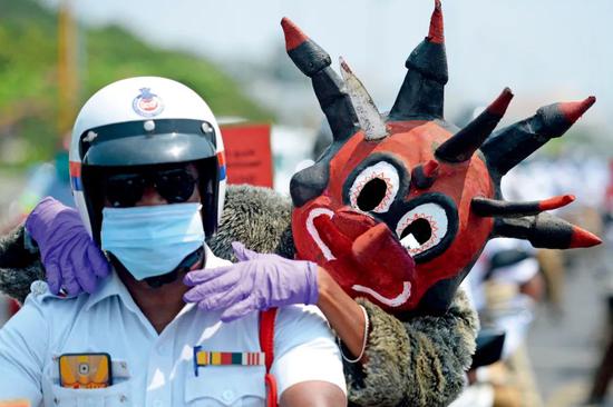 4月29日,在印度金奈,警察装扮成冠状病毒形象上街宣传防疫知识。图/人民视觉