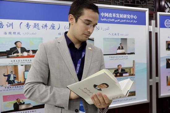 阿尔及利亚驻华大使馆二秘赫鲁飞·比拉勒在中阿改革发展研究中心翻阅阿文版《习近平谈治国理政》第二卷。