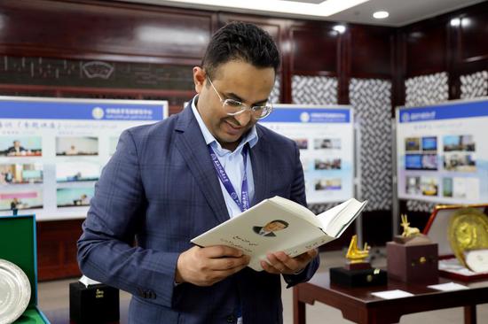 沙特阿拉伯驻华大使馆二秘拉希迪翻阅阿文版《习近平谈治国理政》。