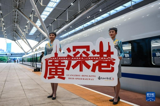 2018年9月23日，广深港高铁全线开通运营，从深圳北站开往香港西九龙站的G5711次高铁列车乘务员展示纪念牌。新华社记者 毛思倩 摄
