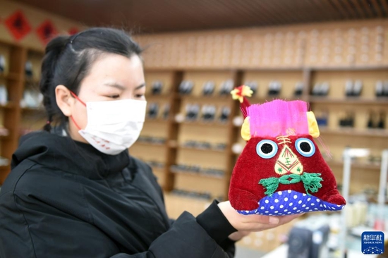  1月28日，在河北省平山县西柏坡镇北庄村电商直播助农惠农展销基地，工作人员展示特色商品。新华社记者 骆学峰 摄