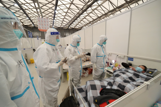上海浦东新区新国博方舱医院w3舱,医护人员在和患者交流.受访者供图