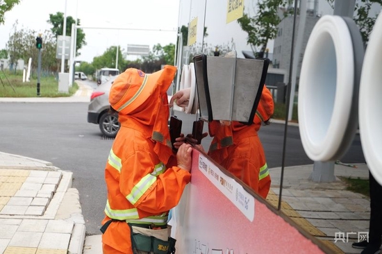  一名环卫工人通过无人驾驶核酸采样车进行核酸采样（央广网发 程楚熙 摄）