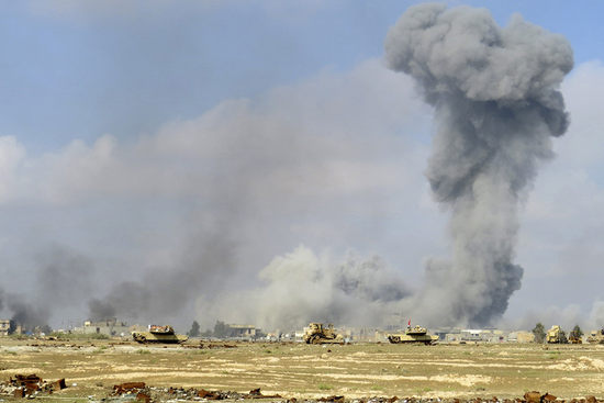 2015年11月21日，伊拉克拉马迪郊区，美军主导的空袭后升起浓烟。