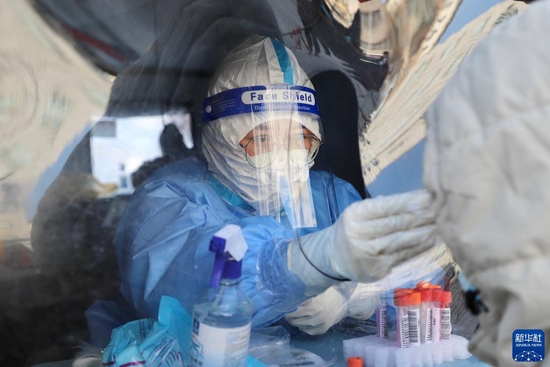 1月27日，在黑龙江绥芬河市一处核酸采集点，医护人员对居民进行核酸采样。新华社记者 徐凯鑫 摄