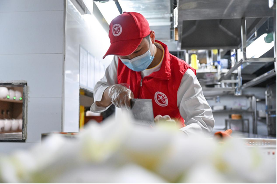 3月18日，志愿者在泉州市一家餐饮店内制作爱心午餐。新华社记者 周义 摄