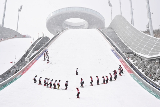  工作人员在国家跳台滑雪中心“雪如意”整理赛道。“雪如意”的设计借鉴了传统文化符号“如意”。