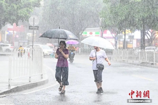 7月3日，广东省广州市，市民雨中出行。中新社记者 陈骥旻 摄