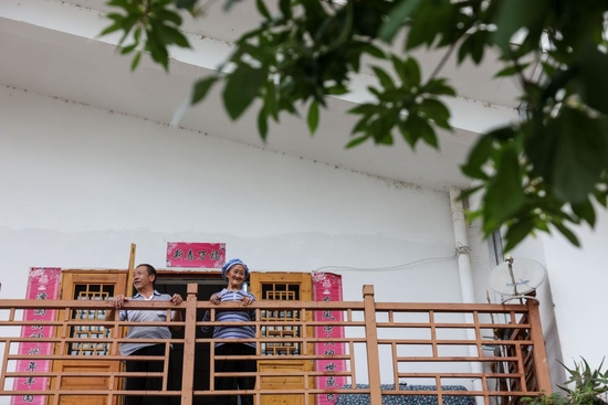 ↑2022年7月19日，76岁的黄小妹（右）与老伴在自家阳台上休息。黄小妹家于2016年7月搬离天眼核心区迁至克度镇马鞍社区