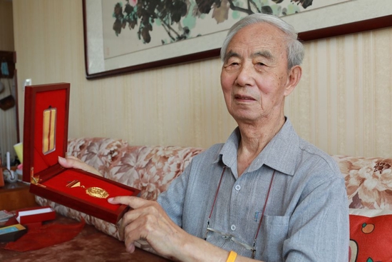  抗战老兵苏英向记者展示中国人民抗日战争胜利70周年纪念章（2020年8月21日摄）。新华社发（戚辉 摄）