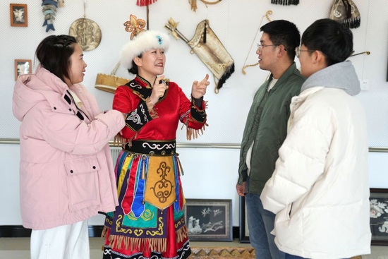  2月23日，在黑龙江省同江市八岔赫哲族乡八岔村伊玛堪传习所，刘蕾（左二）与年轻人交流。新华社记者 王建威 摄