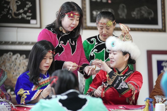 2月22日，在黑龙江省同江市非物质文化遗产展示馆，刘蕾（右一）在学习鱼皮制作技艺。新华社记者 王建威 摄