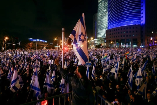 当地时间2023年3月18日，以色列特拉维夫，内塔尼亚胡政府继续推进有争议的司法改革，抗议者手举以色列国旗走上街头抗议。图/IC photo