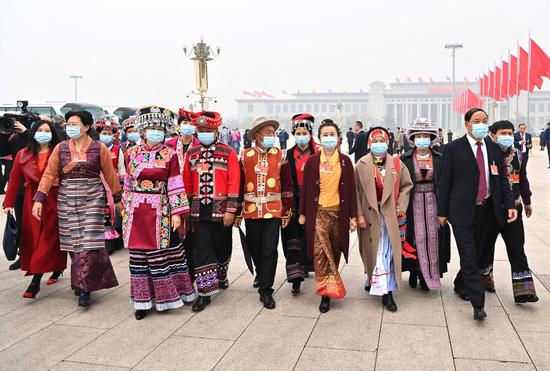 ↑2021年3月5日，十三届全国人大四次会议在北京开幕，全国人大代表走向会场。在十三届全国人大代表中，少数民族代表占代表总数的14%以上，全国55个少数民族都有本民族的代表。