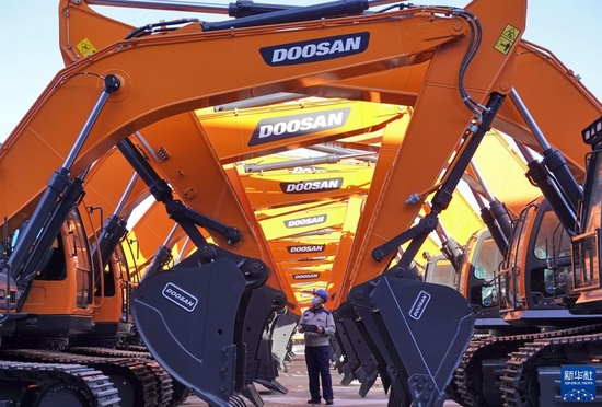 1月17日，在山东烟台开发区一家工程机械有限公司，工作人员对出厂车辆进行检查。新华社发（唐克 摄）