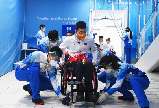  北京冬残奥会志愿者为选手清洁轮椅。