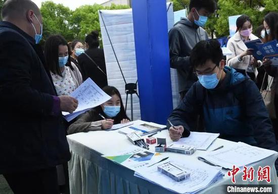 资料图:图为求职者在招聘会现场填写简历。周毅 摄