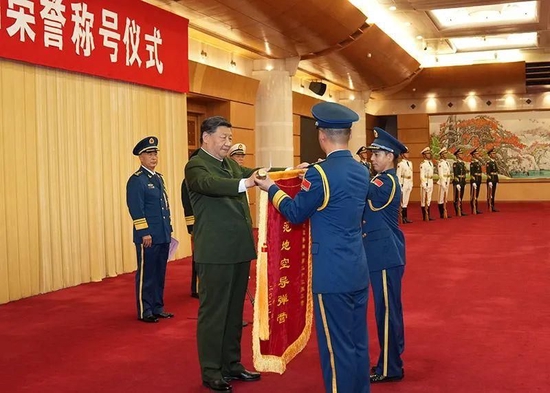 △2022年7月27日，中央军委颁授“八一勋章”和荣誉称号仪式在北京八一大楼隆重举行。习近平主席向获得荣誉称号的单位颁授荣誉奖旗。