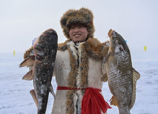  2023年1月7日，在新疆福海县第十六届乌伦古湖冬捕文化旅游节上，渔工展示捕到的鱼。新华社记者 李响 摄