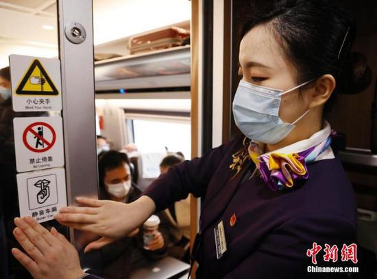 12月24日，列车员在静音车厢内张贴标识。中新社记者 殷立勤 摄
