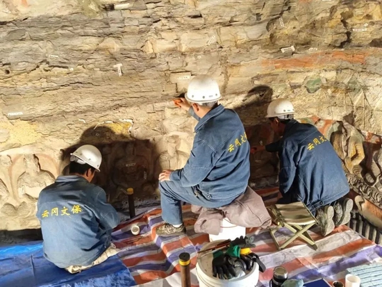  ▲ 云冈石窟文保人员对石窟进行日常维护保养。