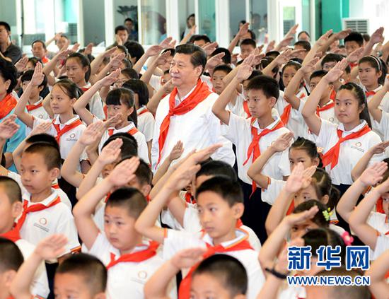 2014年5月30日，中共中央总书记、国家主席、中央军委主席习近平来到北京市海淀区民族小学，参加庆祝“六一”国际儿童节活动。这是习近平参加少先队入队仪式。新华社记者 李涛 摄