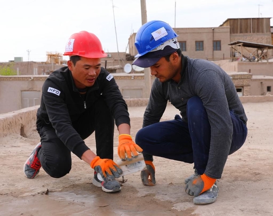 2019年4月22日，在乌兹别克斯坦希瓦古城哈桑·穆拉德库什别吉清真寺，中方文物修复人员正在指导乌方工作人员修复清真寺屋顶。新华社记者 蔡国栋 摄