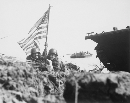  两名美国军官在登陆关岛后插上美国国旗。