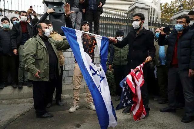 伊朗学生焚烧美国和以色列国旗。图源 ：路透社