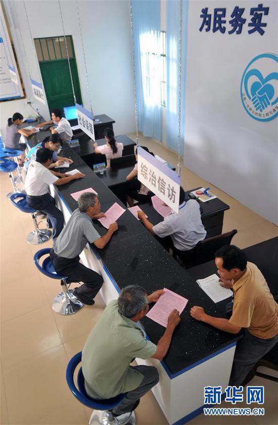 在广西贺州市钟山县清塘镇榕水社区公共服务中心,村民在办理相关事项(2013年6月6日摄)。广西2013年加快构建“一服务两公开”体系(即:政务服务、政务公开、政府信息公开),大力打造服务型政府。 新华社记者 陆波岸 摄