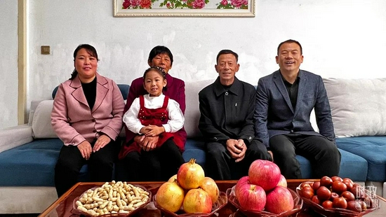  △这是21日当天，许福华（右二）老人一家拍摄的全家福。（总台央视记者邢彬拍摄）