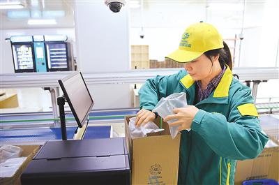 重庆市中医院“聪敏药房”做事人员在对煎煮好的中药进走装箱。新华社记者 王全超摄