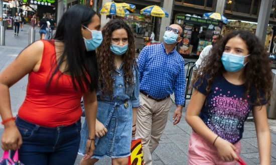当地时间7月27日，美国纽约，民众佩戴口罩走在时代广场上。受德尔塔影响，美国疫情出现反弹。/IC photo