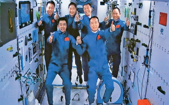 图为2022年11月30日在酒泉卫星发射中心拍摄的神舟十五号航天员乘组与神舟十四号航天员乘组太空合影的画面。　新华社记者 郭中正/摄